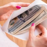 Female holding envelope with cash